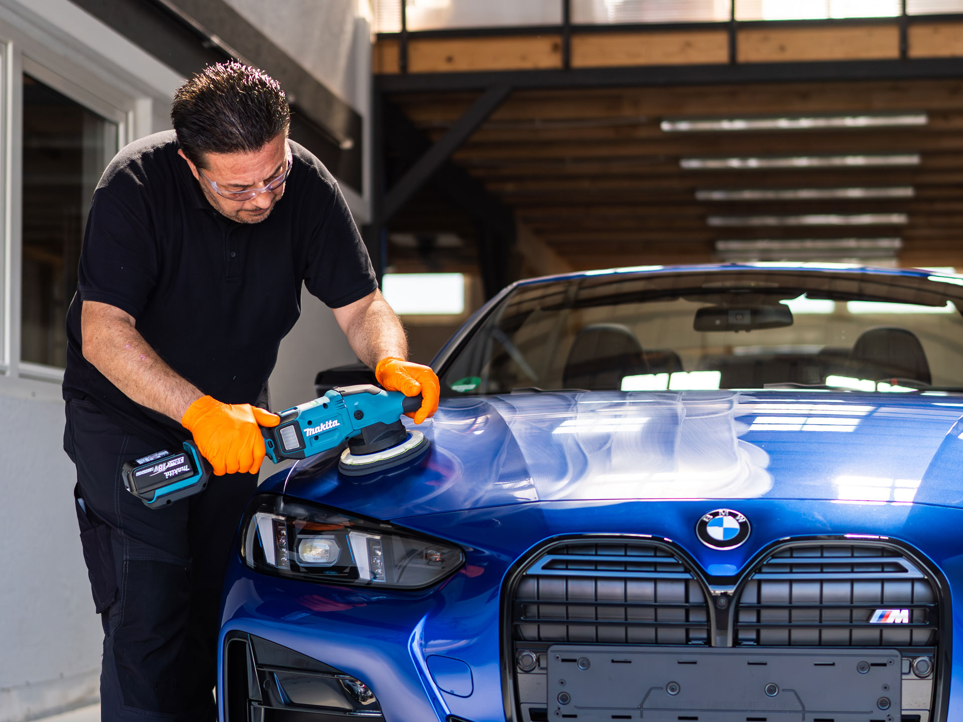 Mitarbeiter poliert BMW M4 in der Werkstatt in Gelsenkirchen